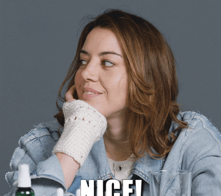 Aubrey Plaza recargando su cabeza encima de su mano derecha mientras sonríe por lo útil que es la función de aviso de llegada de los iPhone.- Blog Hola Telcel