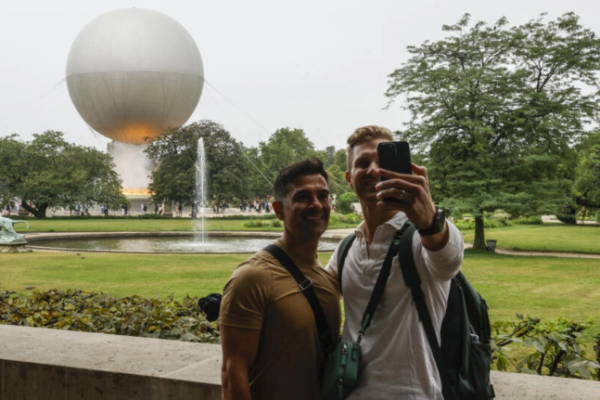 El pebetero olímpico ilumina los ojos de los turistas y el cielo de París