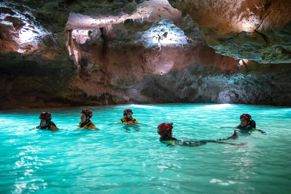 Un grupo de visitantes nada en las cuevas de Sant Josep, en Castellón.